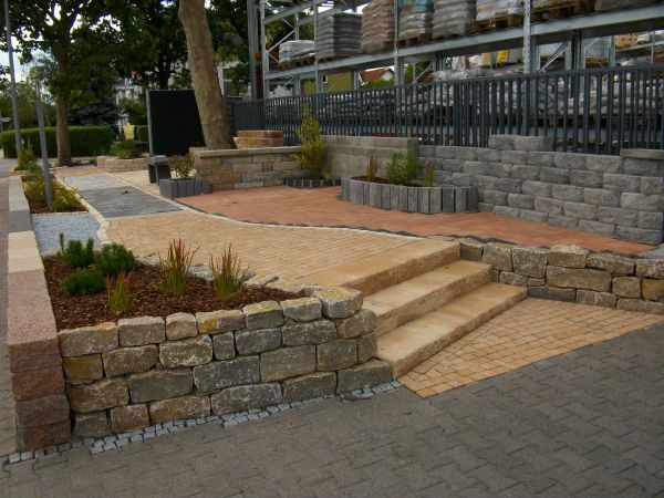 Gepflasterte Terrasse mit Steinmauern und Treppen.